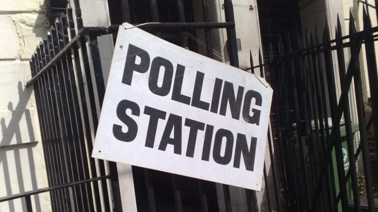 A polling-station sign outside a building.